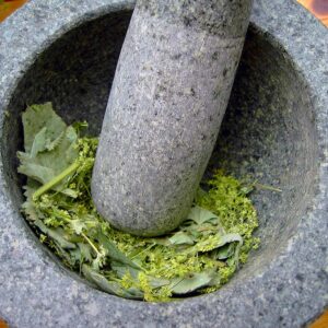 Mortero moliendo Mortero usando los ingredientes para preparar el mejor antiinflamatorio natural
